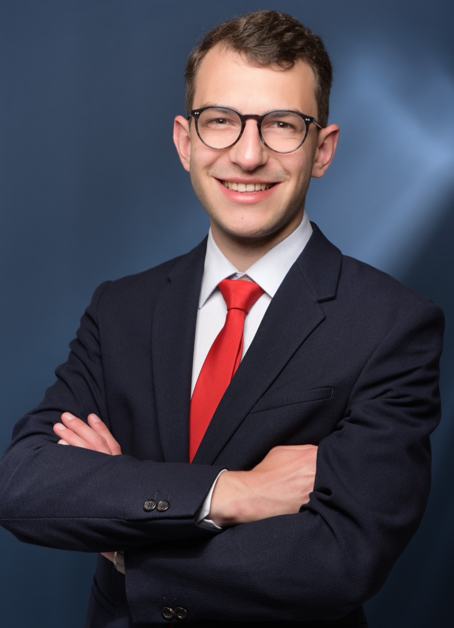 Florian Schröder, Gründer von Landmark Digital, mit verschränkten Armen vor dunkelblauem Hintergrund